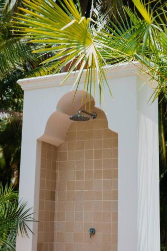 a bathroom with a shower and a palm tree at O - HO Boutique Home in Baan Tai