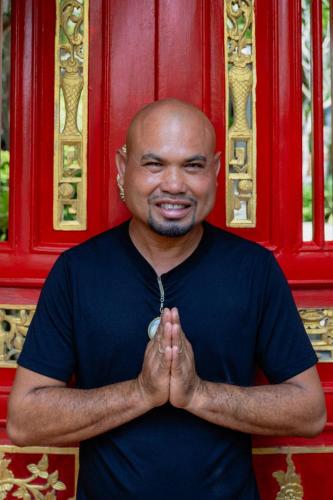 a man holding his hands in front of a red door at O - HO Boutique Home in Baan Tai