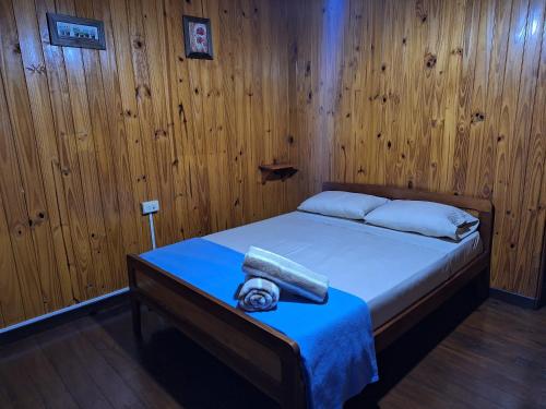 a bedroom with a bed with a wooden wall at La casona in Puerto Iguazú