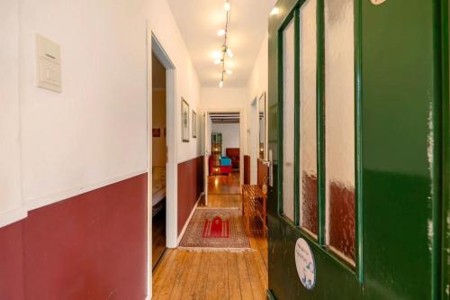 a hallway with green and white walls and wooden floors at Kavaliershäuschen - Urlaub auf dem Weingut in Maring-Noviand