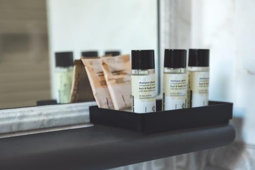 a shelf with four bottles of moisturizers in front of a mirror at Camere Margot in Monterosso al Mare