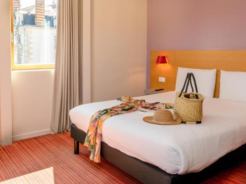 a hotel room with a bed with a hat on it at ibis Styles Le Puy en Velay in Le Puy en Velay