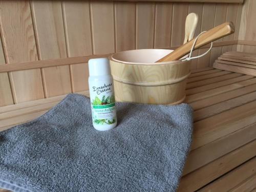 a bottle of sunscreen sitting next to a bucket at Ferienwohnung mit Sauna in Potsdam