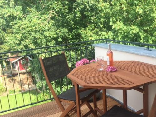 a wooden table and chair on a balcony at Ferienwohnung mit Sauna in Potsdam