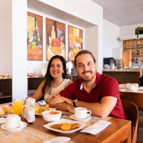 a man and woman sitting at a table with breakfast at Macacona Hacienda Hotel in Ica