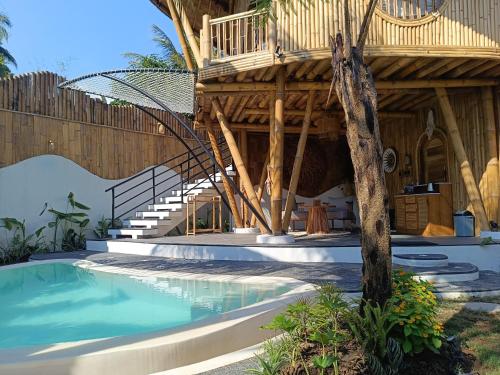 a house with a swimming pool and a wooden building at JinengBali Eco Lodge in Tegalalang
