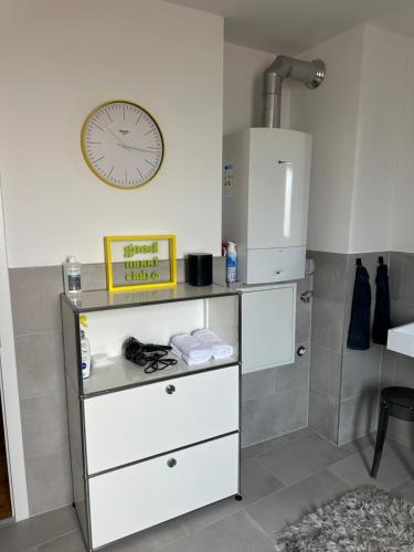 a room with a counter with a clock on the wall at Stylisches Apartment mit großem Tageslichbad am Marktplatz in Leonberg