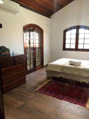 a bedroom with a bed and a dresser at Pousada Sunset Itaúna in Saquarema