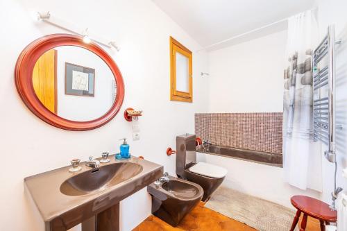 a bathroom with a sink and a toilet and a mirror at Villa Can Torrens de Alcudia in Alcudia