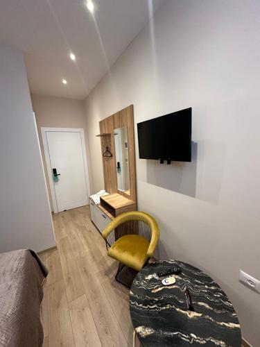 a room with a table and a television on a wall at Luxury Hotel By Gjyshi in Qerrexhias