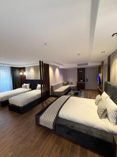 a hotel room with two beds and a couch at Nevizade Avangart Hotel in Avcılar