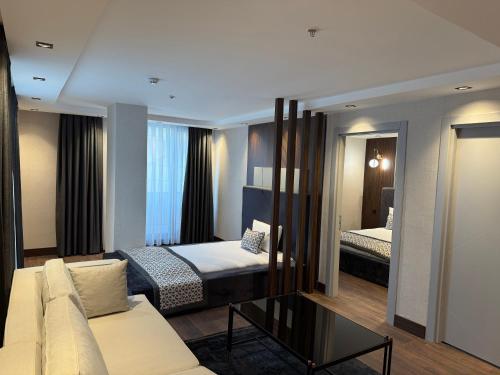 a bedroom with a bed and a couch in a room at Nevizade Avangart Hotel in Avcılar