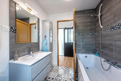 un bagno con vasca, lavandino e doccia di Maison spacieuse avec spa , sauna au pays des Abers ,10 min des plages Bretagne a Lannilis
