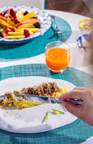 a table with a plate of food and a person holding a cell phone at Hotel Piccolo Sant'Andrea in Praiano