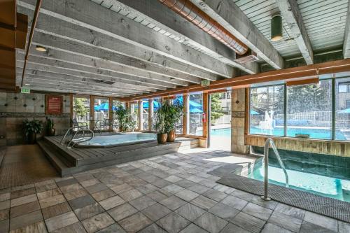 une piscine intérieure avec un bain à remous dans un bâtiment dans l'établissement Mall 1421 by SummitCove Lodging, à Keystone