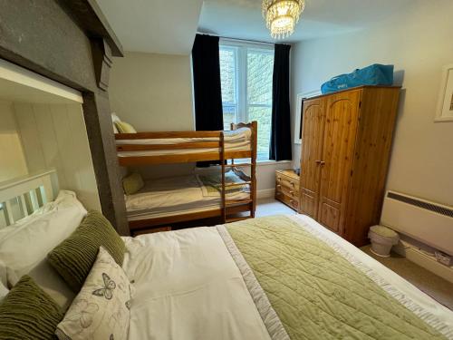 a bedroom with a bed and a crib in it at Hargate Hall Self Catering in Buxton