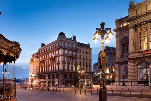 a city street with buildings and a light pole at Escale Oceania Marseille Vieux Port in Marseille