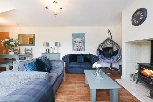 a living room with a couch and a fireplace at JOIVY Greenknowes Lodge with Hot Tub and Wood Burning Stove in Kelty