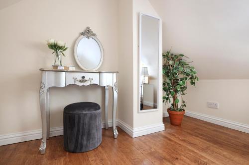a dressing table with a mirror and a stool at JOIVY Greenknowes Lodge with Hot Tub and Wood Burning Stove in Kelty