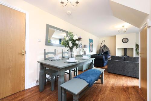 a living room with a table with a vase of flowers at JOIVY Greenknowes Lodge with Hot Tub and Wood Burning Stove in Kelty