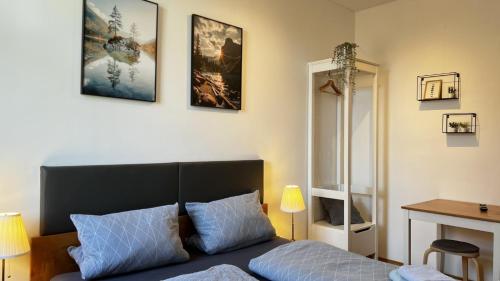 a bedroom with a bed and some pictures on the wall at Hotel Bühlerhof in Heddesheim