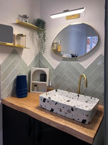 La salle de bains est pourvue d'un grand lavabo sur un comptoir en bois. dans l'établissement Gabin sous les Oliviers, à Gallargues-le-Montueux