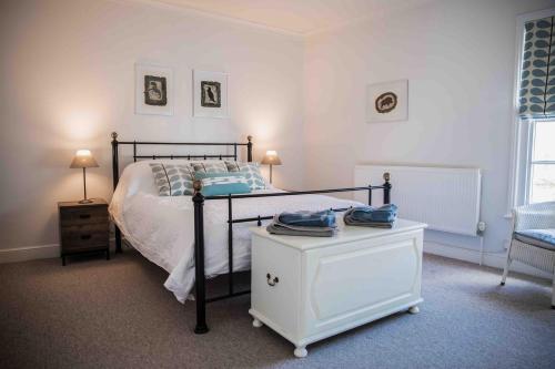 a bedroom with a bed and a table with phones on it at Hope Cottage - Charming 3 bedroom house, Southwold in Southwold