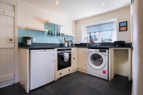 a kitchen with a washing machine and a washer at Fold Cottage, Outgate near Ambleside in Hawkshead