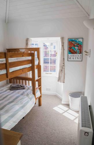 a bedroom with two bunk beds and a desk at Hope Cottage - Charming 3 bedroom house, Southwold in Southwold