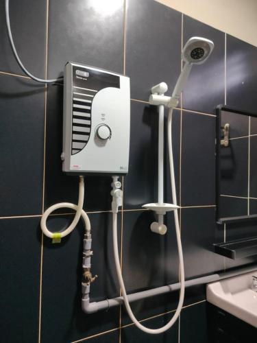 a bathroom with a hair dryer on a wall at KASMA HOMEsTELs in Kampong Permaisuri