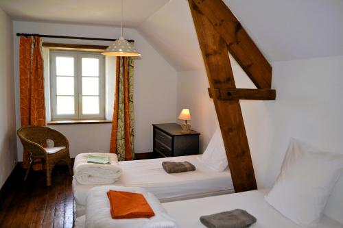 une chambre avec deux lits et une fenêtre dans l'établissement Gîte des Sangles, à La Cambe