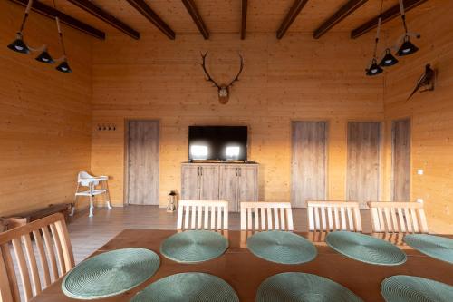 a room with a table and chairs and a flat screen tv at Casa Rustică in Călăţele
