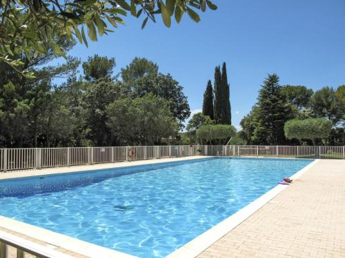 une piscine avec une clôture et des arbres dans l'établissement La Pierrerie Bambou, à Tourtour