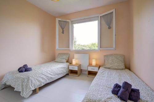 Un dormitorio con dos camas y una ventana en Le Van Gogh 3 chambres 4 lits, en Tournefeuille