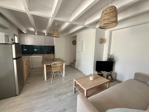 a living room and kitchen with a couch and a table at Villa ensoleillée Richelieu in Cap d'Agde