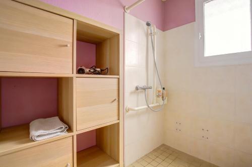 Un baño con ducha y muebles de madera. en Le Van Gogh 3 chambres 4 lits, en Tournefeuille