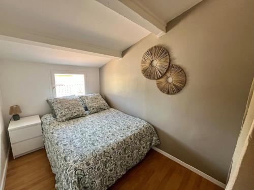 une chambre avec un lit et un miroir au mur dans l'établissement Villa ensoleillée Richelieu, au Cap d'Agde