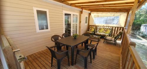 - une terrasse couverte avec une table et des chaises dans l'établissement Mobil-home climatisé 6 personnes, à Lège-Cap-Ferret