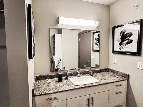 a bathroom with a sink and a large mirror at The Green Onyx Escape in Des Moines