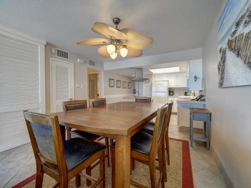 a dining room table with chairs and a ceiling fan at Island House BeachFront Condo Hotel in Corpus Christi