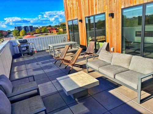 a patio with a couch and chairs on a balcony at Cobalt Cove (132) in Des Moines