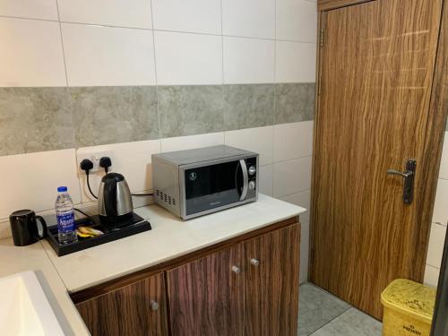 a kitchen with a microwave on a counter at Presken Hotels @ Victoria Island in Apese