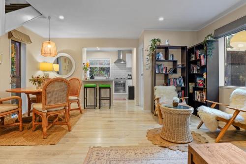 a living room with a table and chairs at Seaside Bougainvillea Retreat close to Beaches in Auckland