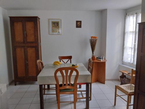 a kitchen with a table and some chairs and a table and a room at La Miloute in Vendôme