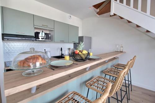 une cuisine avec un comptoir, une table et des chaises dans l'établissement Les Beaux-Arts - Duplex au Centre Ville, à Bourges