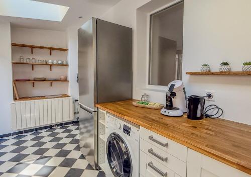 une cuisine avec un réfrigérateur et une machine à laver dans l'établissement Appart avec terrasse, vue & parking - hyper centre, à Chartres