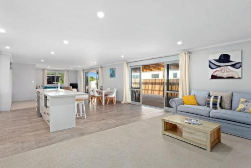 a living room with a blue couch and a table at Waiotahe Executive Getaway in Opotiki