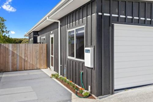 a black and white building with a garage at Waiotahe Executive Getaway in Opotiki