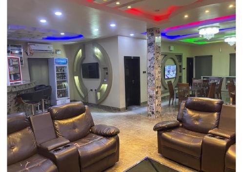 a living room with leather couches and a bar at Grand Diamond Hotels & Suites LTD in Owerri