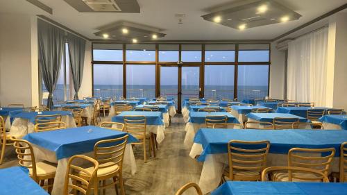 カットーリカにあるDiplomat Marineの青いテーブルと椅子と窓のある部屋